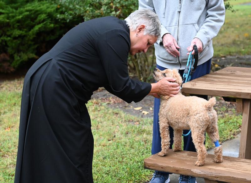 The Rev. Shelley D. McDade of the parish of St. George’s Chapel and All Saints’ Church gives a blessing to Teddy, a 10-year-old miniature poodle.