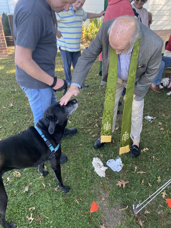 The Rev. Dr. S. Willard Crossan III gives a blessing to black lab Emily.