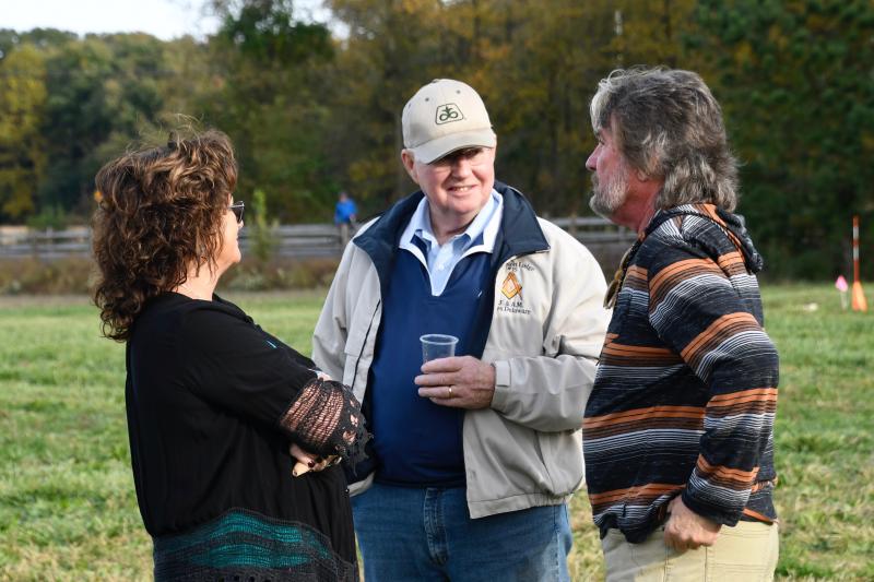 Walt Hopkins, center, converses with land trust vice chairman Russ McCabe, right, and his wife, Michele McCabe.