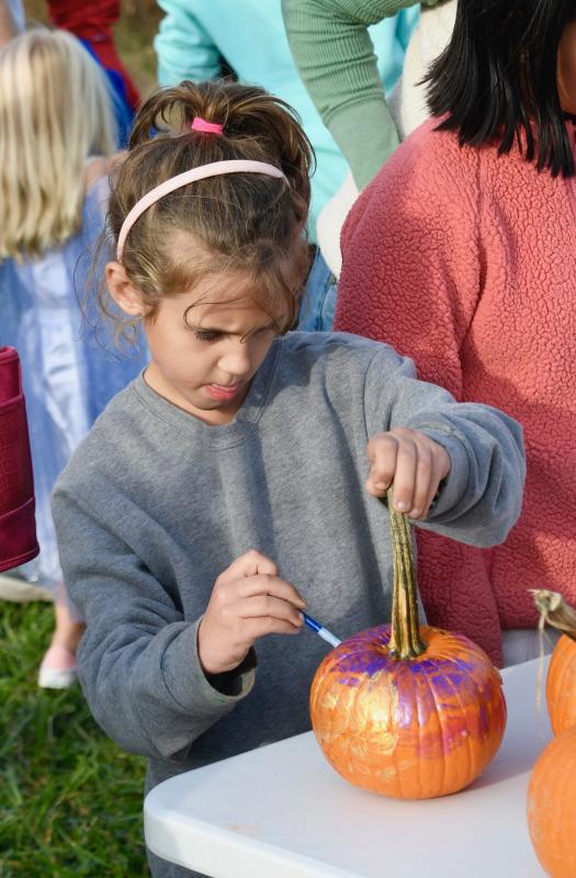 Harper Myers of Milton paints a face on a pumpkin in anticipation of Halloween.