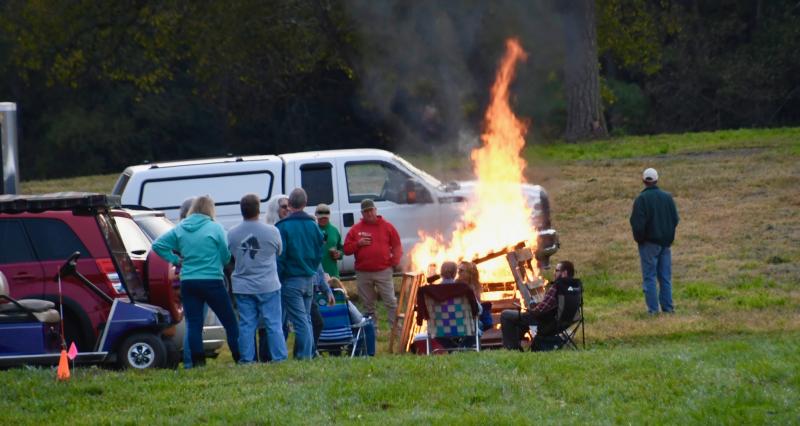 As the sun sets, flames rise from a bonfire set up by Coastal Christmas Trees.