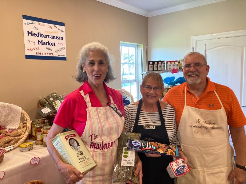 Holding some of the items available at the Mediterranean market are (l-r) Michele Forzley, Donna Moore and Tim Moore.