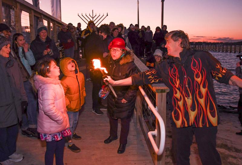 Twins Addie and Dax Lerer, 9, get help from Kate Masterton as they put out the fire on Cascading Carlos’ juggling clubs.