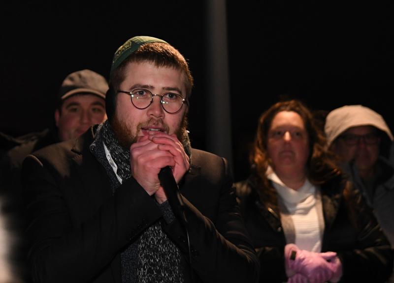 Rabbi Sholom Vogel speaks to community members gathered to watch the public lighting of the menorah on the Baywalk in Dewey Beach.
