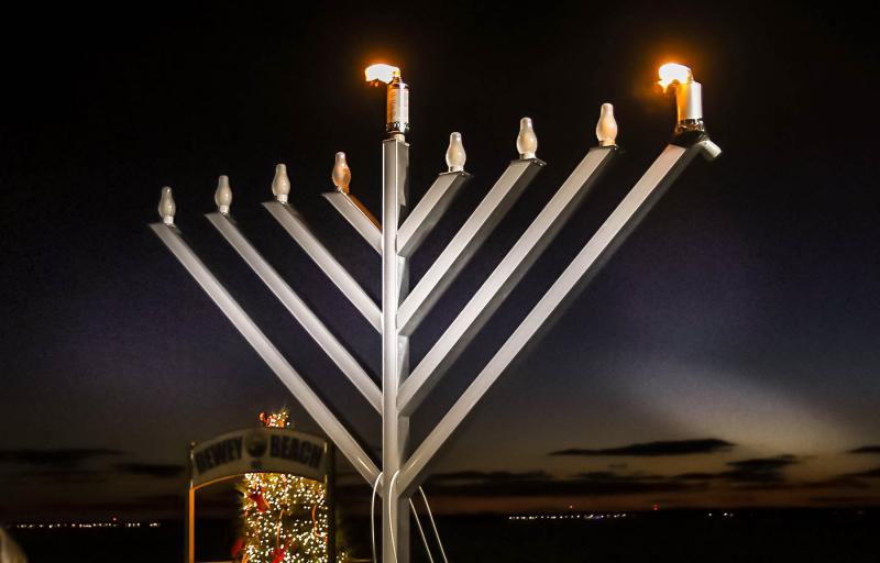 The first lights shine bright on the menorah at the Baywalk in Dewey Beach. The Chabad of Southern Delaware held the lighting on the first night of Chanukah Dec. 18. DAN COOK PHOTOS