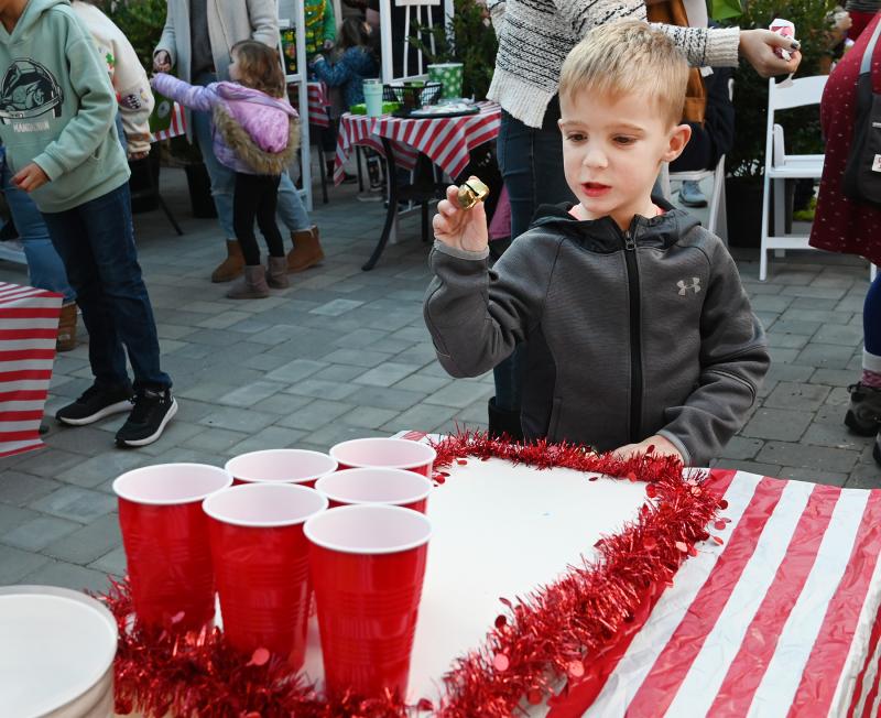 Blake Rollins, 4, of Milton tries to toss a jingle bell into a cup.