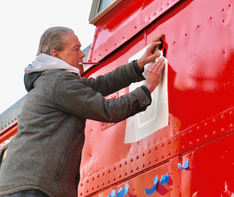 Southern Delaware Signs’ D.J. Baker gets started on a lettering project early Jan. 10 on the restored caboose.