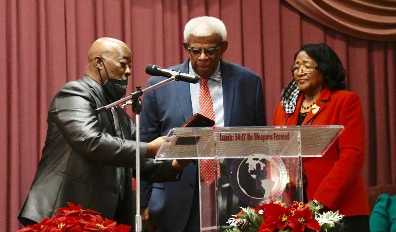 MLK Celebration Organization President Clem Jordan, left, and treasurer Janie Miller, present the Rev. George Meekins with plaque of appreciation.