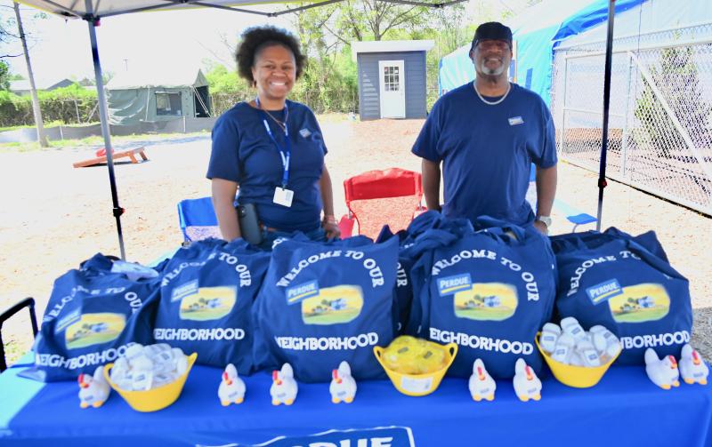 Perdue Farms Field Recruiter Shacre Jones, left, and Day Shift Safety Supervisor Kendall Dorsey set up a job fair booth at the Georgetown Pallet Village.