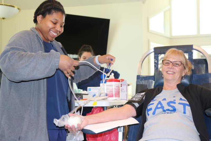 “A family that donates together, stays together!” Akyra Boswell, left, gleefully gets Pam Costanzi ready to donate. Costanzi and her husband, Kevin Murphy, are the duo that donates.