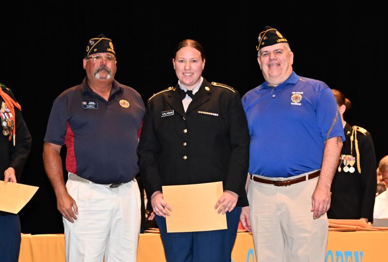 Jenna Calhoun receives the American Legion Post 17 Medal of Merit from Steve Barrow, left, and Steve Missimer.