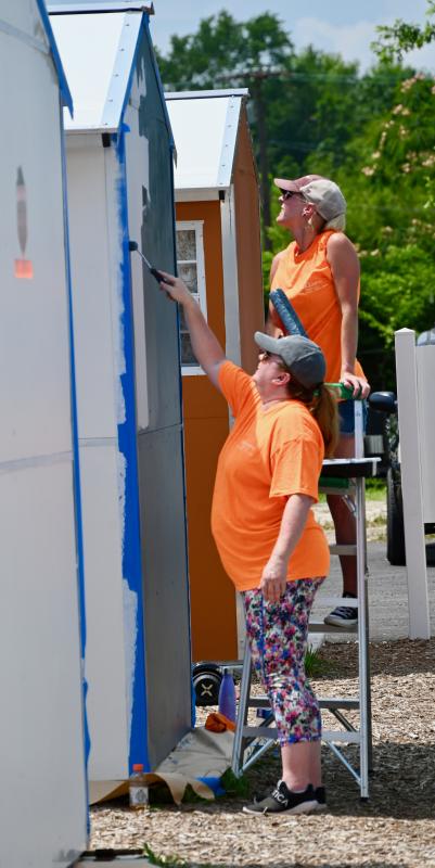 Sarah Rigot, on ladder, and Kati Brown are part of a team of employees from Faw Casson CPA in Rehoboth Beach who are donating their time to the project.