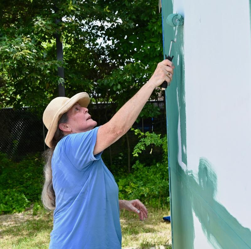 Julia Smith works in the shade of a grove of trees bordering the Pallet Village.