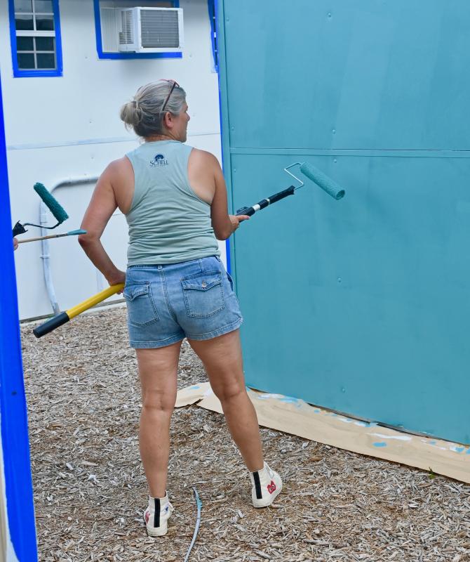 Schell Brothers employee Alyssa Titus applies a finishing coat to one of the shelters.