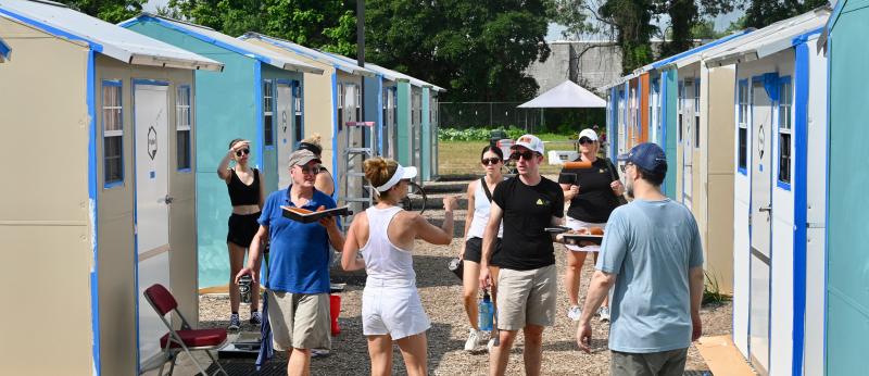 Kathleen Schell, center in white, directs a crew of volunteers to their next painting assignment.