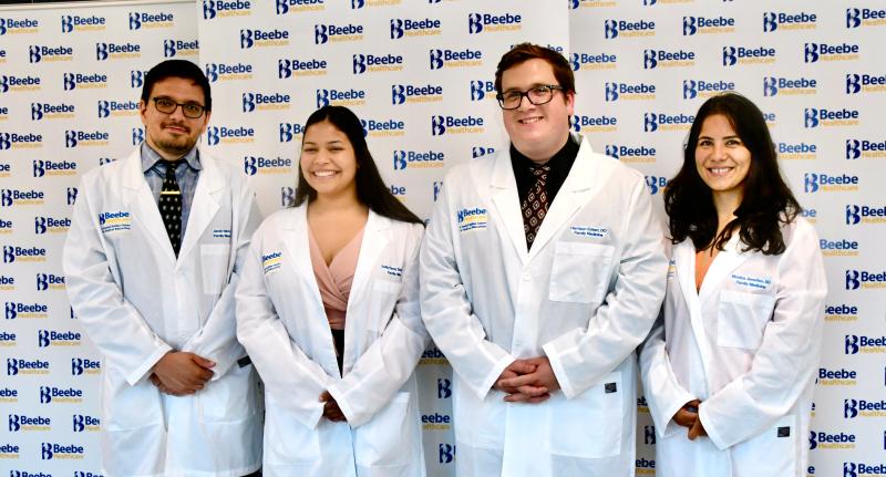 The first Beebe family medicine residents receive their white physician’s coats during a July 13 ceremony. They are Jacob Valvis, DO; Sofia Perez Delgado, DO; Harrison Eckert, DO; and Monica Javadian, MD. RON MACARTHUR PHOTOS