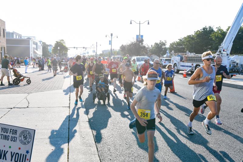 Runners burst from the sun at start of Fire Fightin’ 5K. DAVE FREDERICK PHOTOS