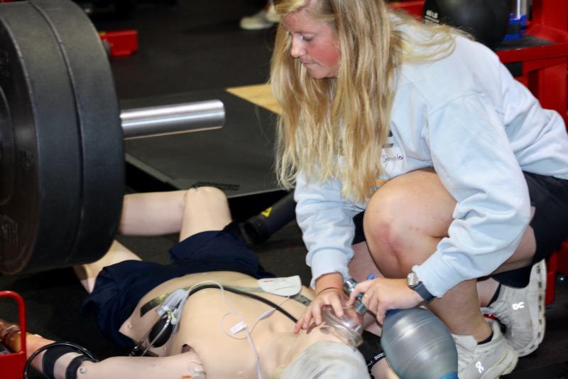 Cape Henlopen athletic trainer Ashley Schuster renders aid to someone who was working out when they had a heart attack and ended up in between two machines.