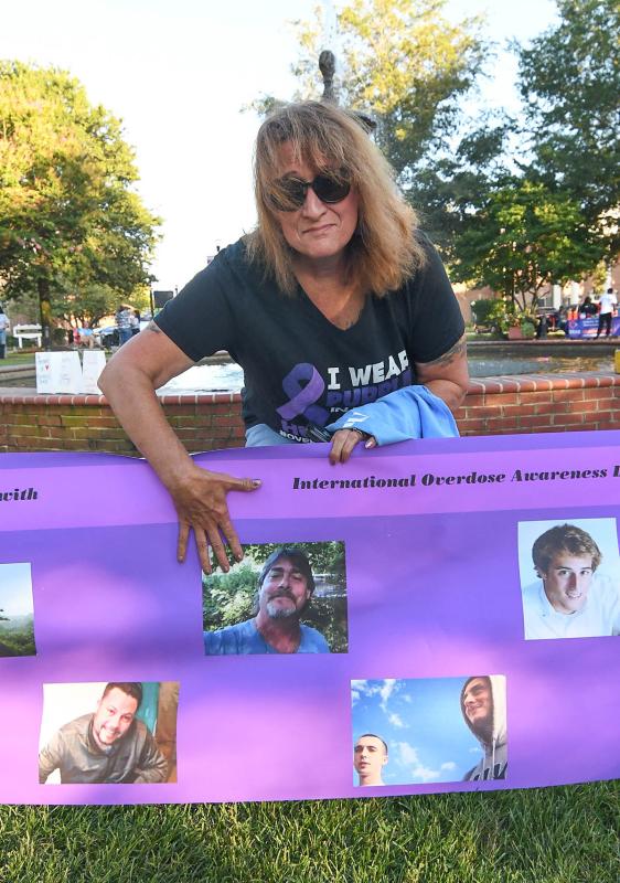 Lisa Brown of Ocean View hugs the banner picture of her husband Mark, who died of an overdose in January 2021.