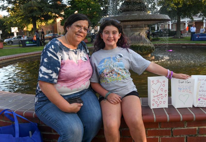 Aurora Palverento, 10, and her grandmother Teressa Payne sit with the paper bag luminaries they made for Aurora’s parents who died from an overdose.
