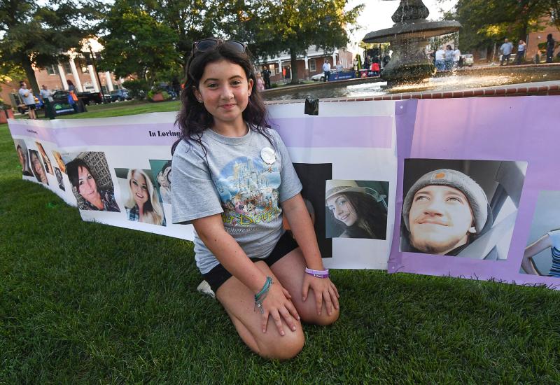 Aurora Palverento sits next to her mother Samantha’s picture on the banner of remembrance for the people lost to overdose. DAN COOK PHOTOS