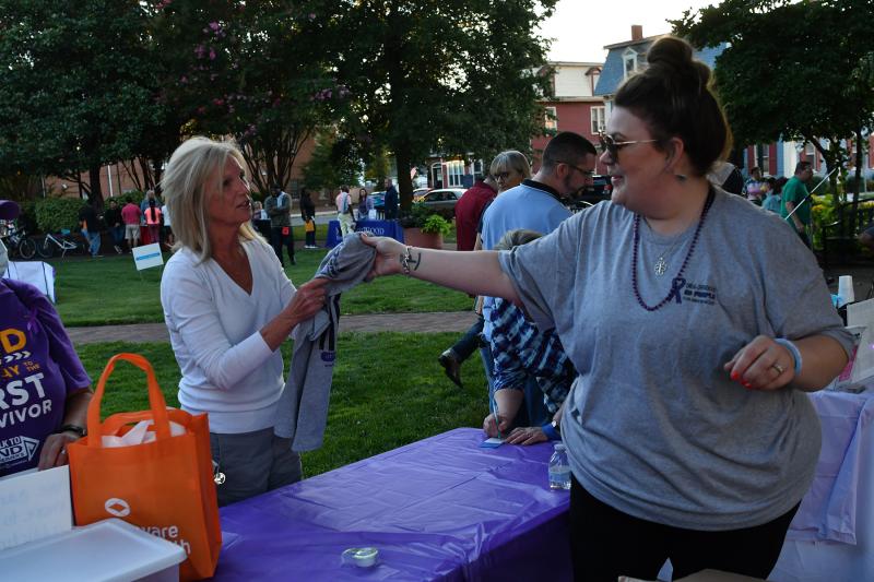 Leah Parrick, right, of Impact Life of atTAcK Addiction gives a T-shirt to Ronda Douglas.