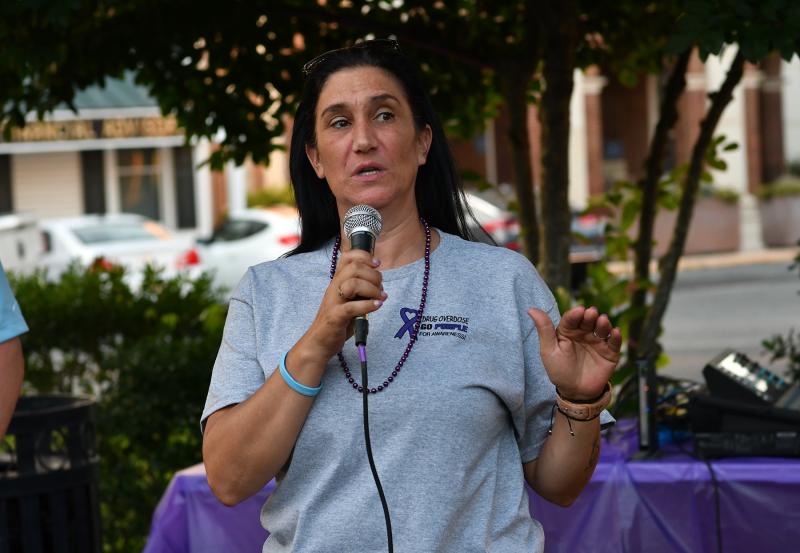 Amy Rust of atTAcK Addiction speaks with attendees gathered at the event.