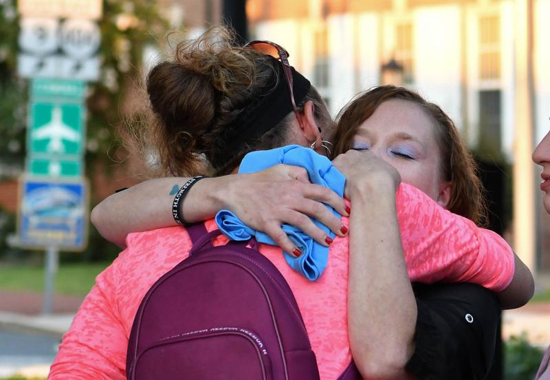 Two friends hug as they remember their loved one who died from a drug overdose.