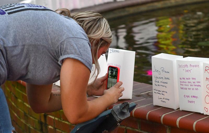 Shelby Meredith takes a picture of the paper bag luminaries to honor her brother Joey Prouse.