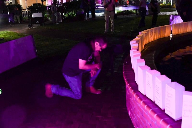A man says a prayer for a loved one lost to overdose.