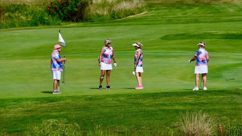 A foursome finishes their day on The Peninsula course at the ninth hole near the clubhouse.
