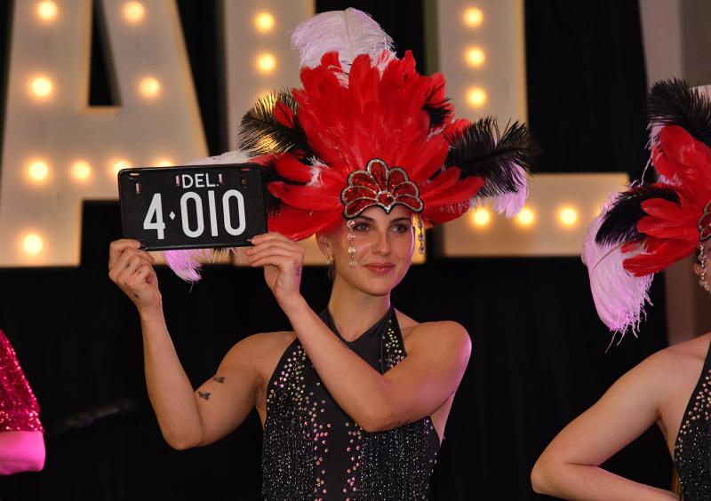 Dancer Emily Gulsby displays the four-digit tag up for the live auction. It brought in $15,000.