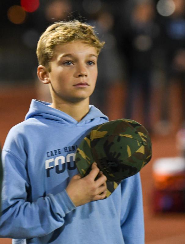 Ball boy James Frederick listens to the national anthem before the Cape at Dover football game.