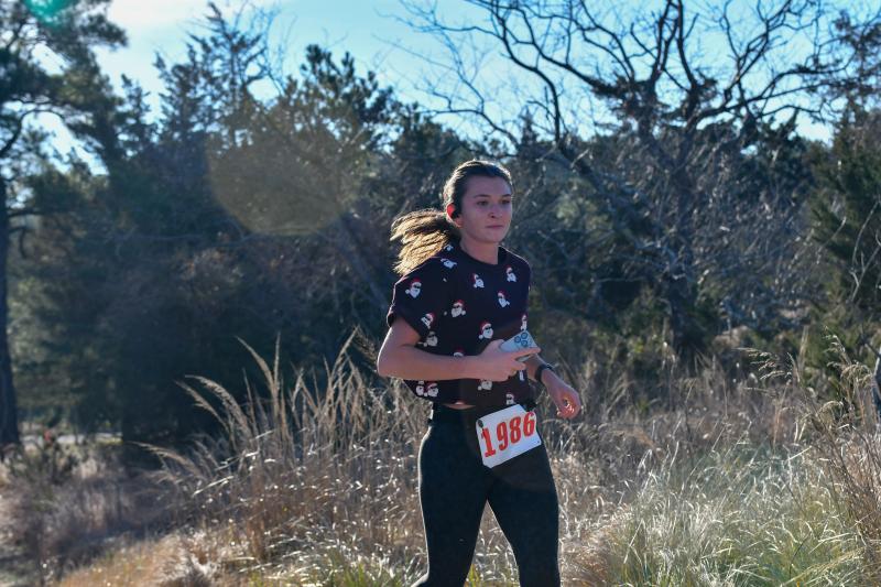 Hadley Rhue, a former Cape runner, crosses the finish line third with a time of 22:47.