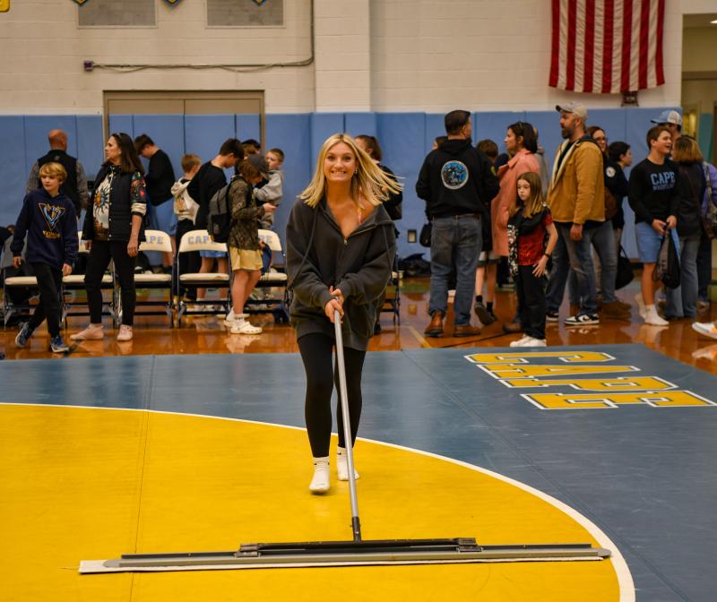 Jocelyn Fisher cleans the wrestling mat. DAVE FREDERICK PHOTOS