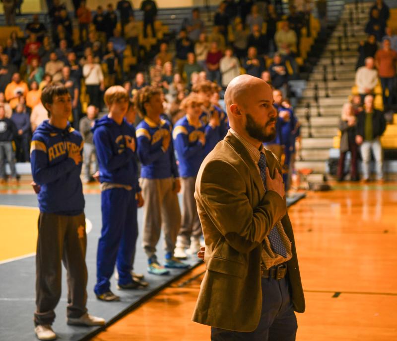 Caesar Rodney coach Trey Mitchell and his team during the national anthem.