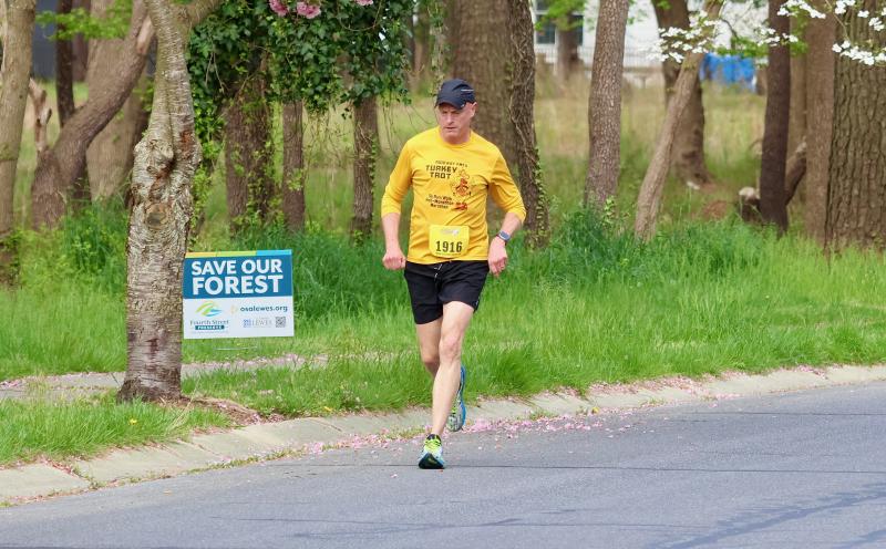 Robert Saylor of State College, Pa., runs by the Fourth Street Preserve on his way to the finish line. Saylor came in first in the masters category.