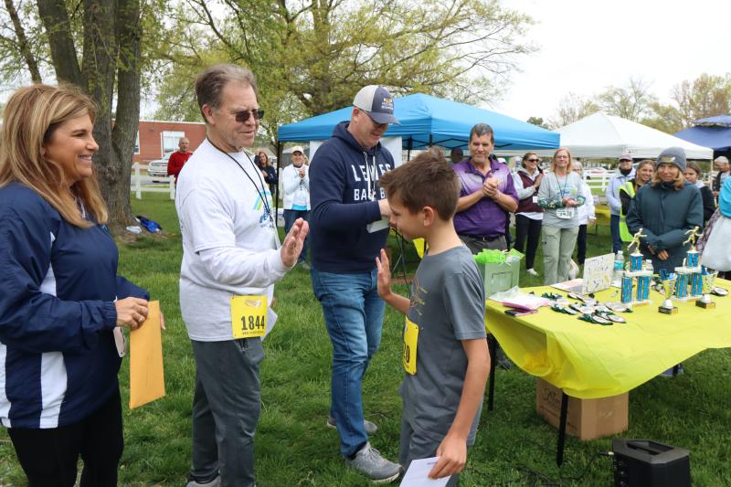 Grayson Charles high fives Open Space Alliance Chair Jim Ford at the awards ceremony following the Race for Open Space.