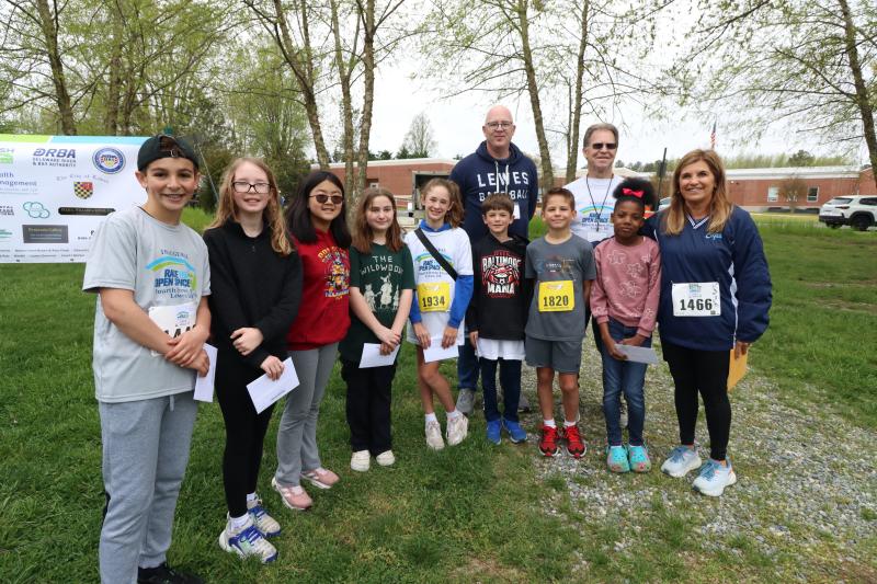 Lewes Elementary School art contest winners who were present at the race include (l-r) Lincoln Fyock, Natalia Tikiob, Anna Liang, Addie Lerer, Sadie Strumpf, Colin Strumpf, Grayson Charles, Madison Miller, and Kim Corbidge, principal of Lewes Elementary School. In back are Sen. Russ Huxtable, D-Lewes, and Open Space Alliance Chair Jim Ford.