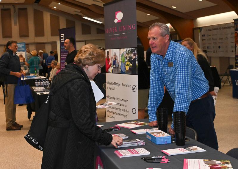 Chip Leonard, right, of Silver Lining Home Health Care gives information to Chris Muto.
