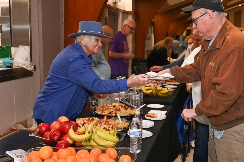 Rotary member Pat Campbell-White, who volunteered at the event, serves some goodies to Chuck Hartsock.