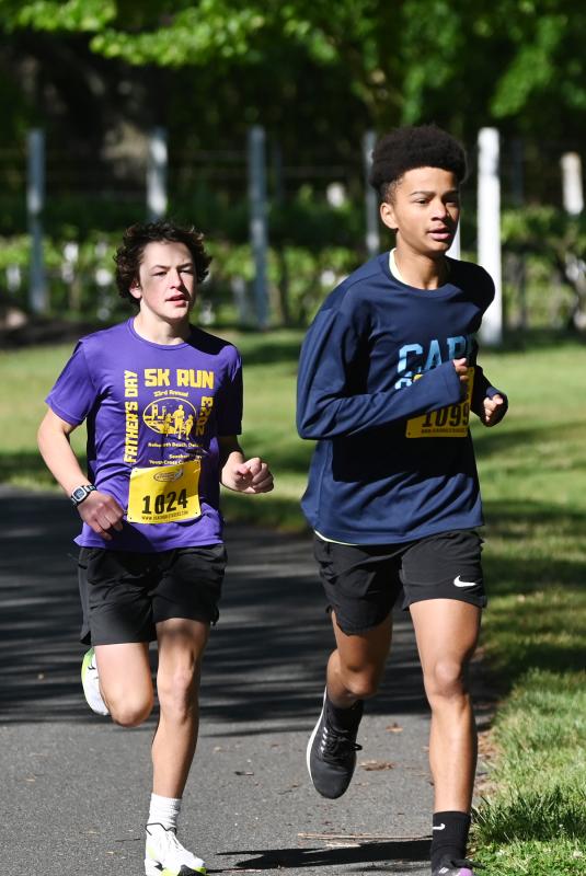 Quade Cummings, 14 of Milford, left, and Kihara Ngido, 14, of Lewes run in stride through Nassau Valley Vineyards early in the race.