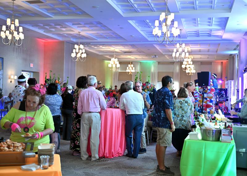 The crowd is engrossed in conversation and enjoying appetizers.