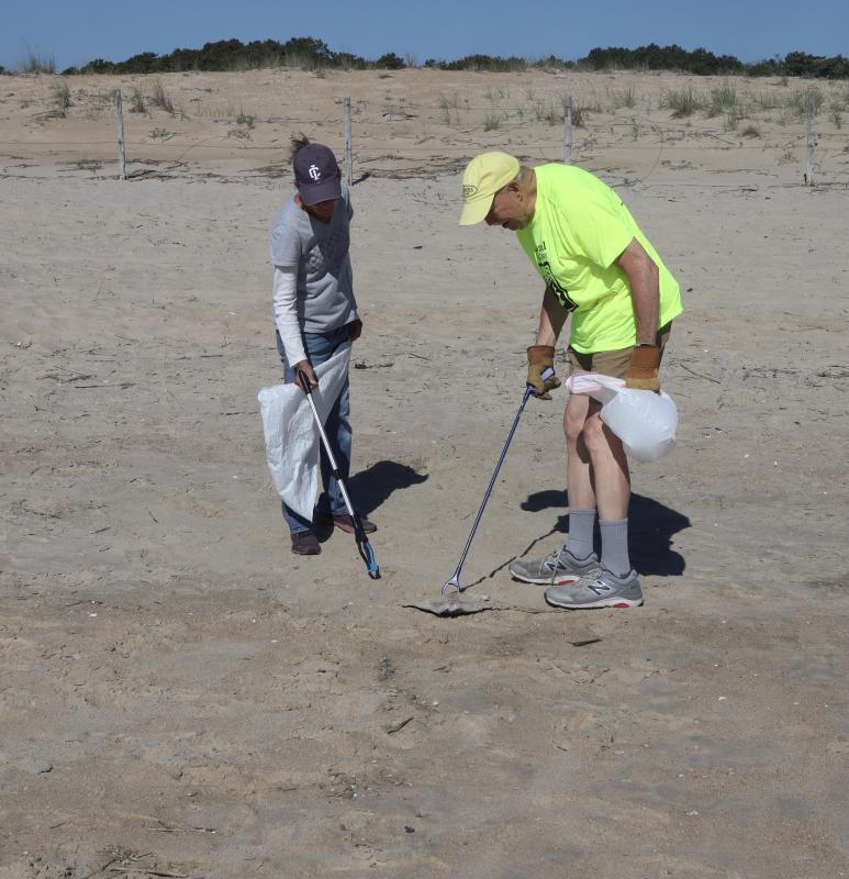 Lynn DeCourcey, left, and Paul Montgomery help clean up the beach just south of Herring Point.
