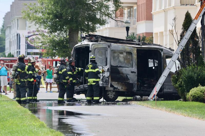 Firefighters worked to put out the fire that gutted the van and damaged at least one apartment.