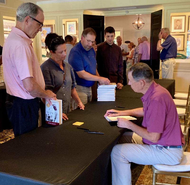 Author John Riley signs copies of his new biography of Bill Hyndman at Huntingdon Valley Country Club June 13, in a room filled with Hyndman memorabilia. FRITZ SCHRANCK PHOTO