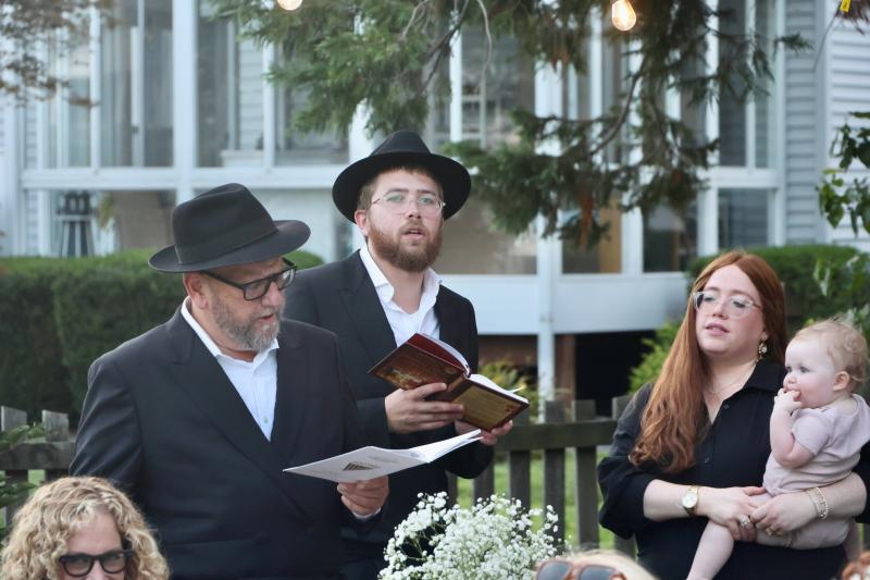 Guest speaker David Nesenhoff, left, and Rabbi Sholom Vogel lead prayers before dinner. Chanele Vogel, right, looks on. Nesenhoff is an internationally known speaker who has embarked on a mission to oppose anti-Semitism.