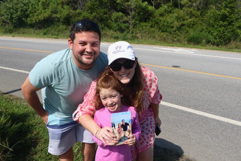 Miriam Moskowitz, center, holds a photo of her and President Joe Biden that was taken on the beach two years ago. Her father Jason, left, and mother Shana were hoping the president would stop and sign their daughter’s picture. BILL SHULL PHOTOS