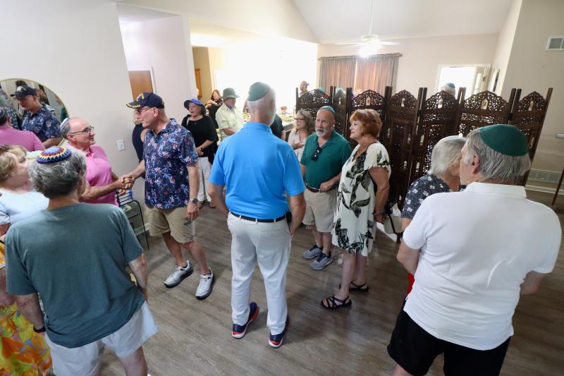 Some of the people who attended Shabbat Under the Stars talk inside before heading outside for dinner.