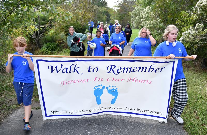 Walk to Remember participants carry the banner around Blockhouse Pond during the 2023 event. DAN COOK PHOTO